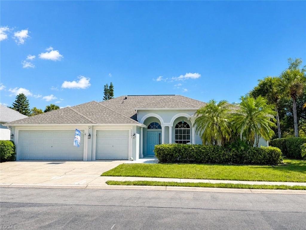 Single family home at 14897 Calusa Palms Dr with a three-car garage, arched entry and palm trees