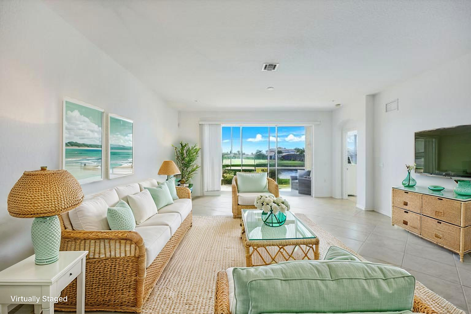 Bright living room in soft coastal green with a view to the lanai and lake (virtually staged)