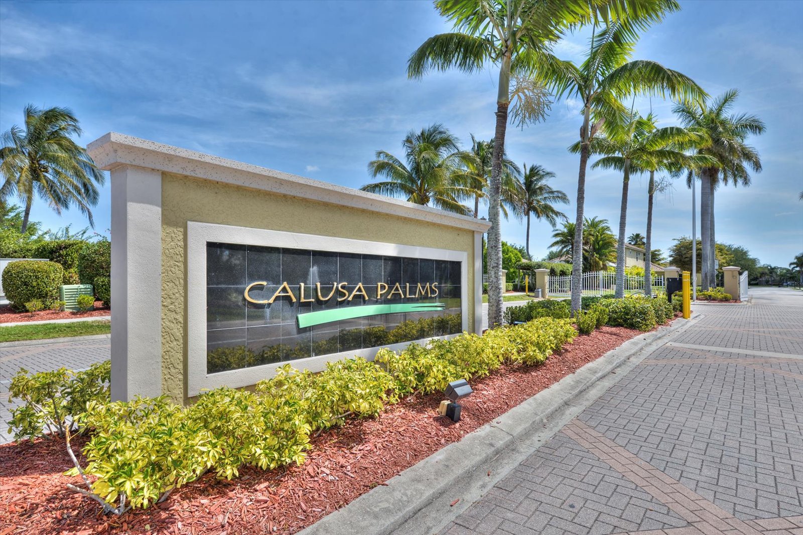 The Calusa Palms entrance sign framed by tall palm trees